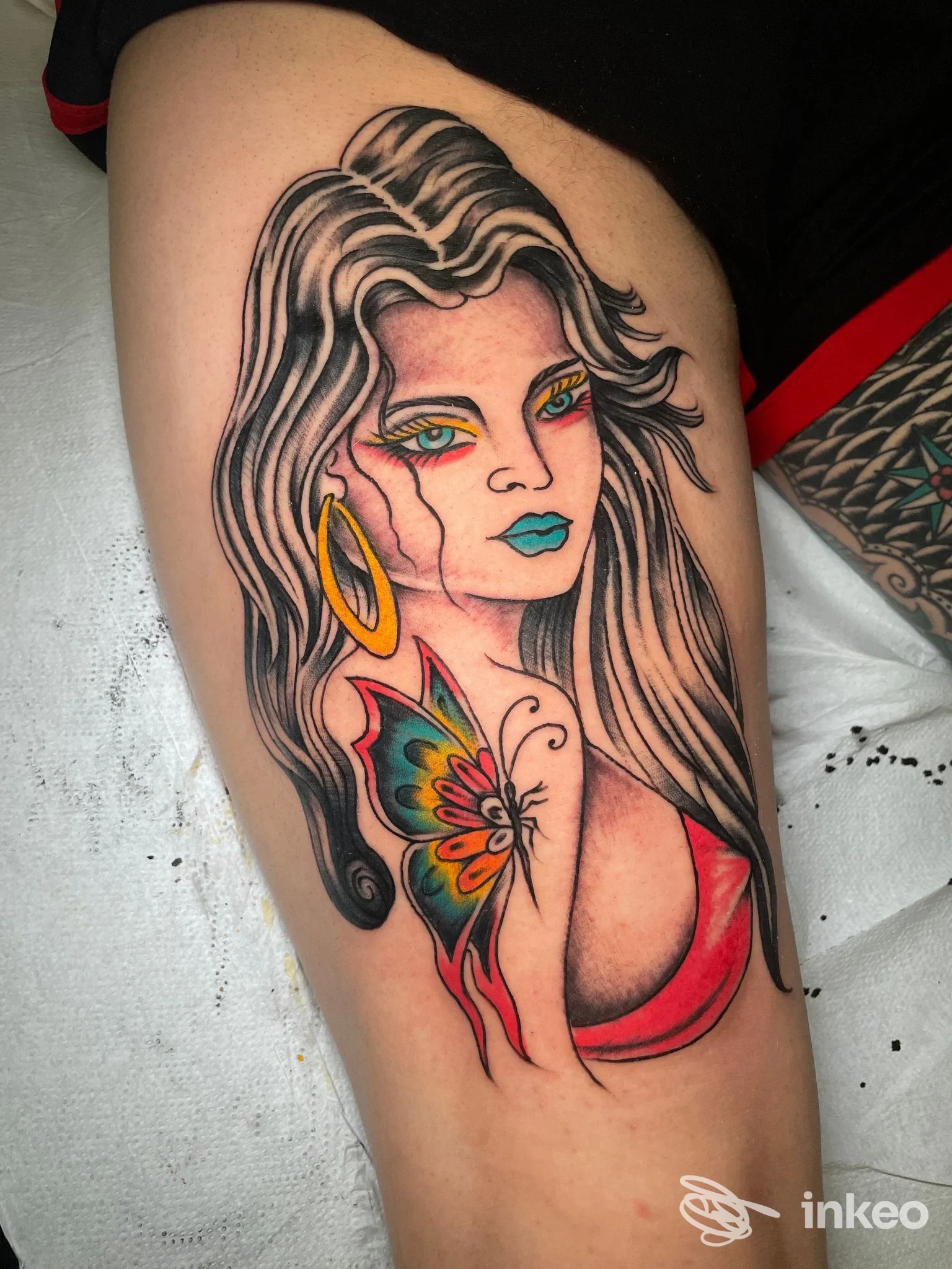 Tatuaggio colorato su braccio con donna stilizzata e farfalla, foto inviata dallo studio Anima tattoo club a Foggia.