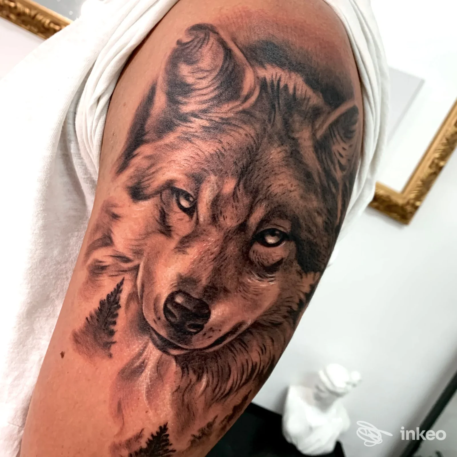 Grande tatuaggio realistico di un lupo sul braccio superiore, con dettagli in bianco/nero e sfumature, fotografato presso Artink Tattoo Studio a Triggiano.