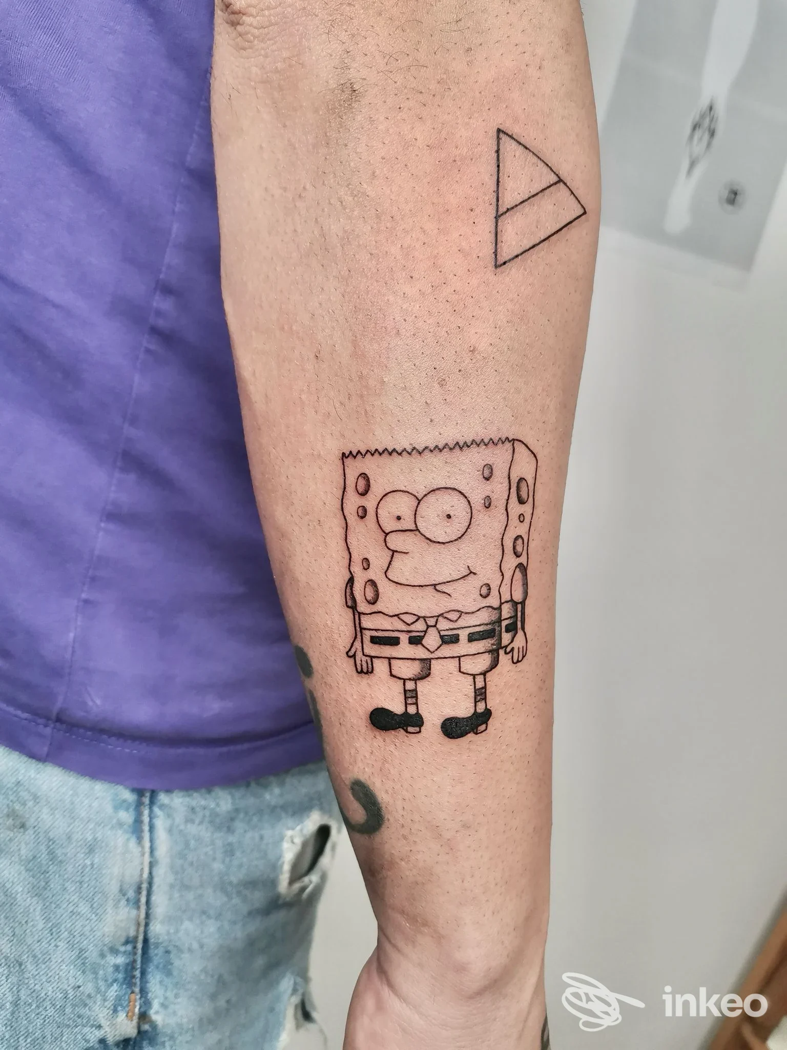 Tatuaggi linework su avambraccio con SpongeBob stilizzato e piccolo triangolo, foto per BadNeedle Tattoo Shop, Nardò.
