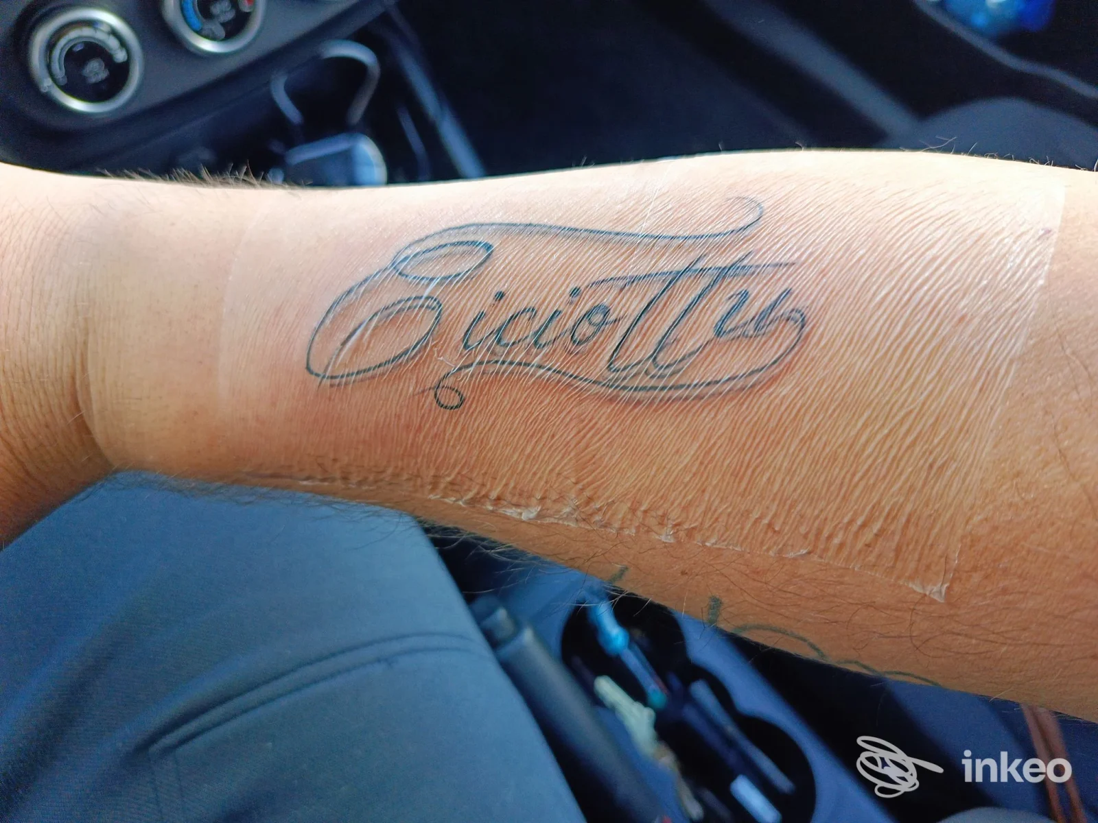 Tatuaggio calligrafico sull'avambraccio fotografato all'interno di un'auto, immagine inviata da Bee Ink tattoostudio, San Donato di Lecce.