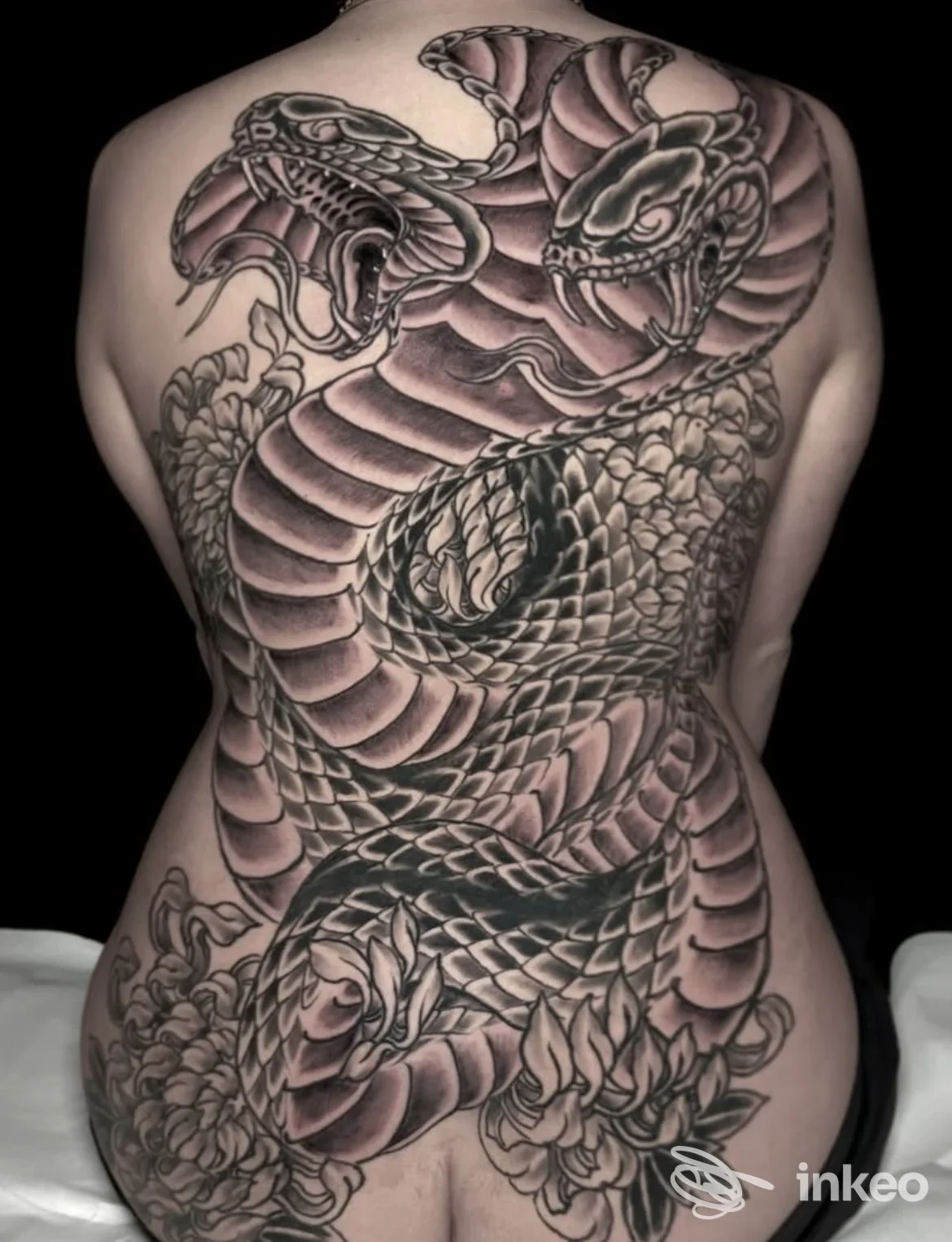 Grande tatuaggio schiena raffigurante un serpente avvolto con fiori — Beyond the Skin Tattoo Studio, Foggia.