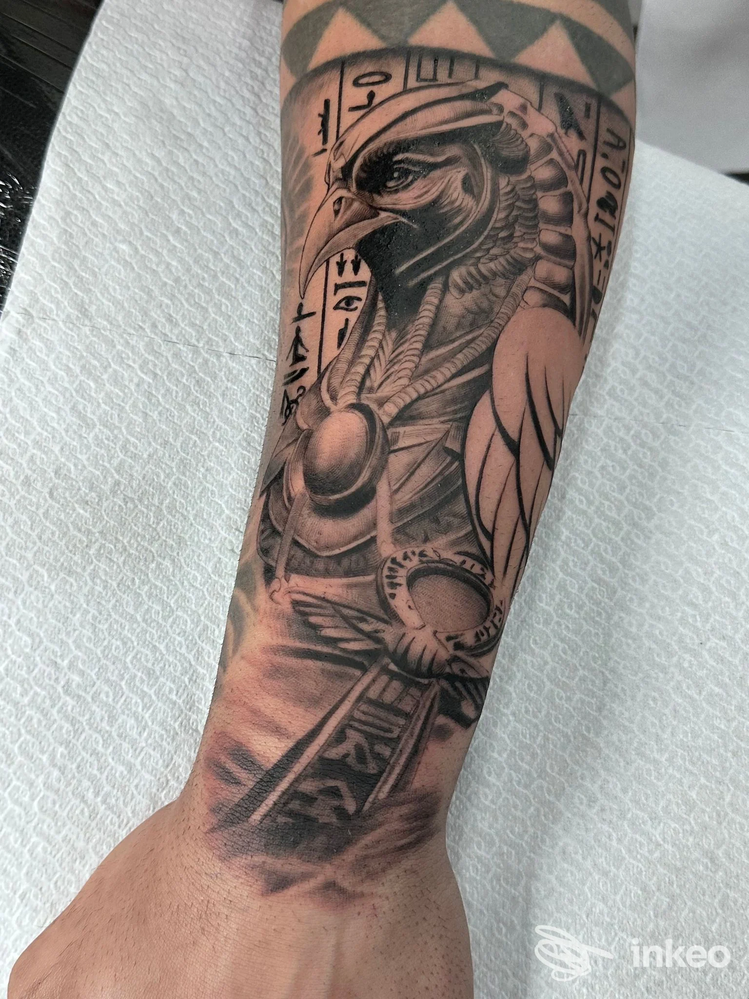 Tatuaggio su avambraccio raffigurante divinità egizia a testa di falco, Black Blood Ink - Taranto.