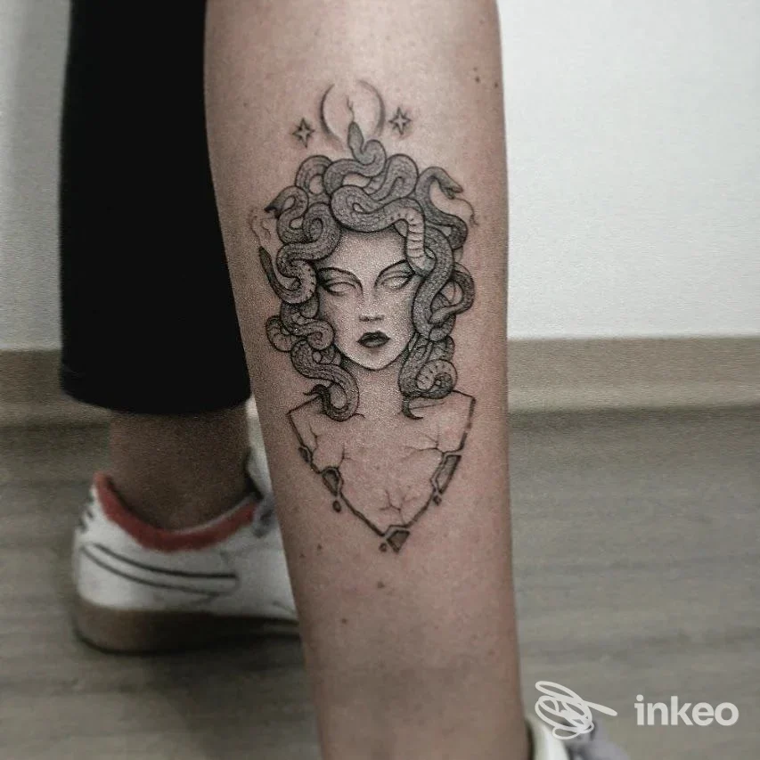 Tatuaggio raffigurante una testa di Medusa in bianco e nero sul polpaccio, realizzato con linework e dotwork. Black Medusa Tattoo, Trani.