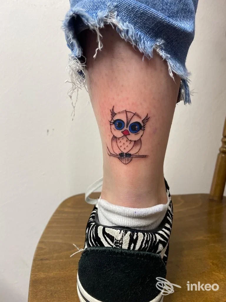 Tatuaggio colorato di un gufetto sulla caviglia, fotografia eseguita presso Cassiopeia Tattoo a Castro.