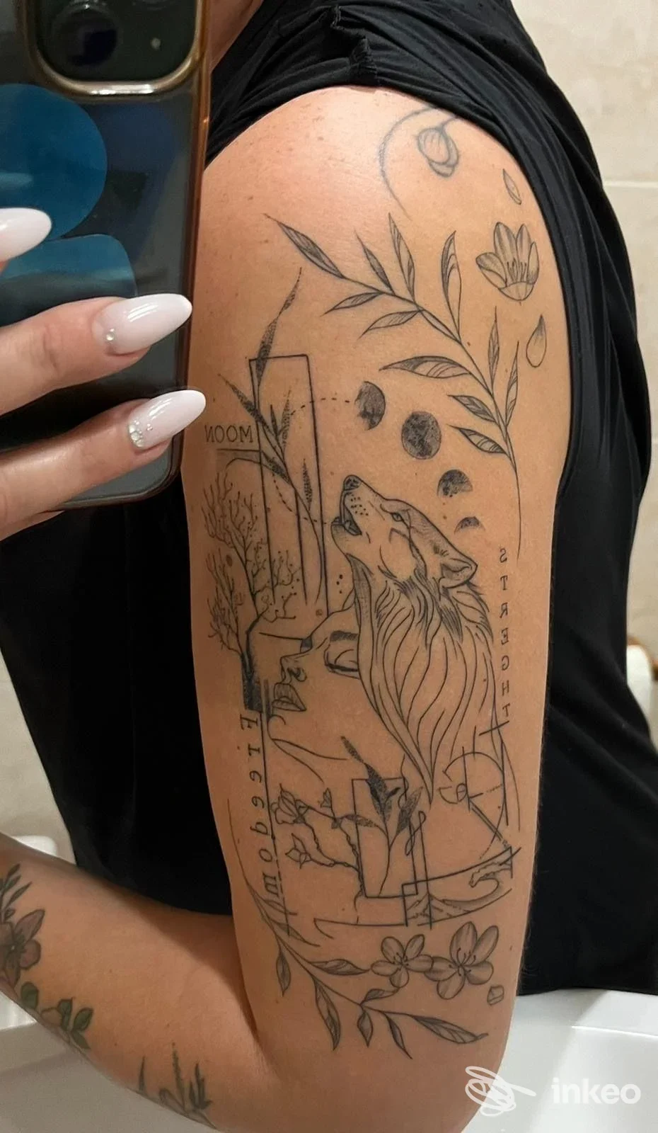 Tatuaggio a linee nere su braccio superiore con leone stilizzato e motivi botanici — Cassiopeia Tattoo, Castro.