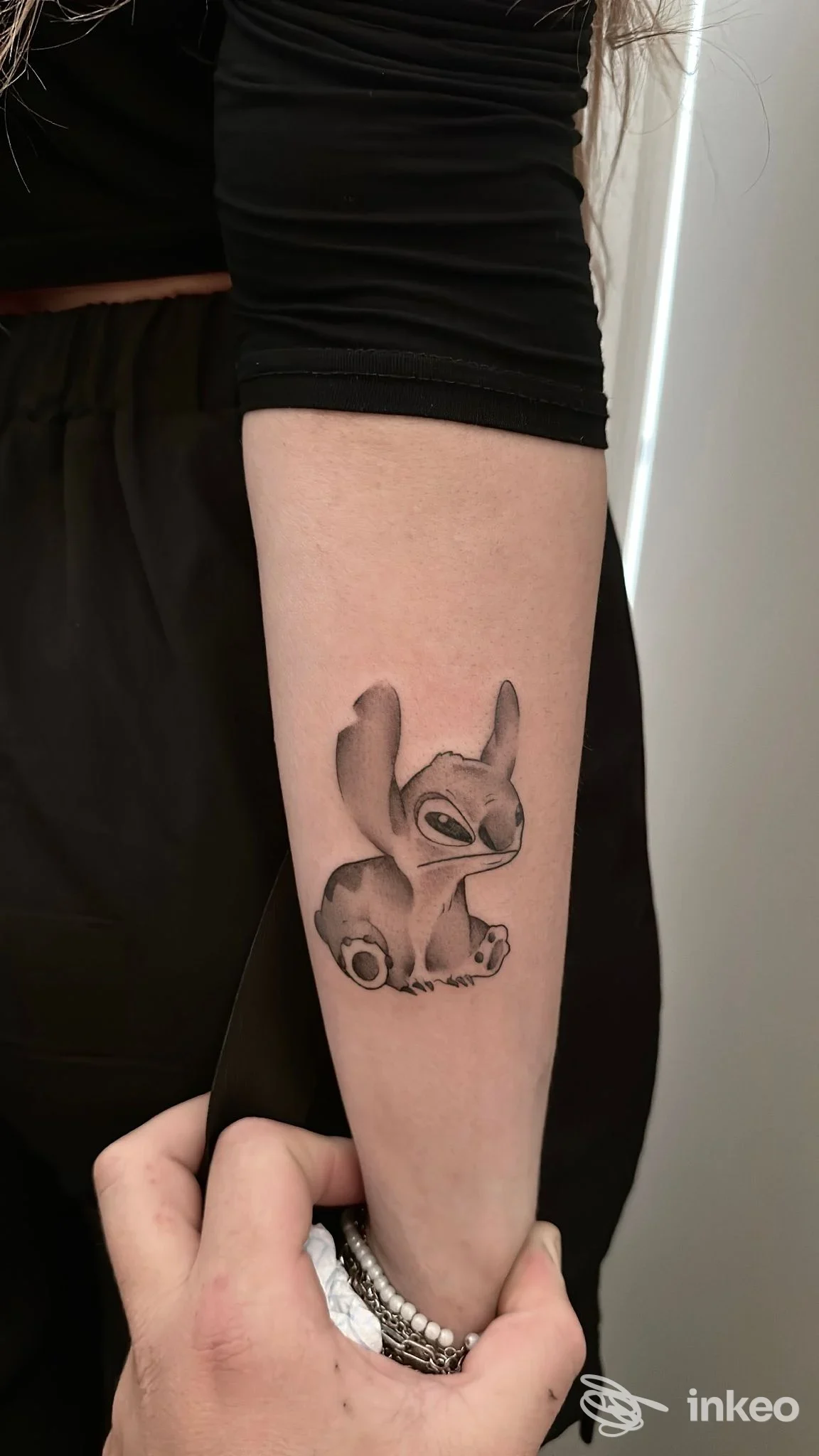 Tatuaggio in bianco e nero di un personaggio stilizzato sull'avambraccio interno, fotografia fornita da DAN TATTOO STUDIO, Ceglie Messapica.