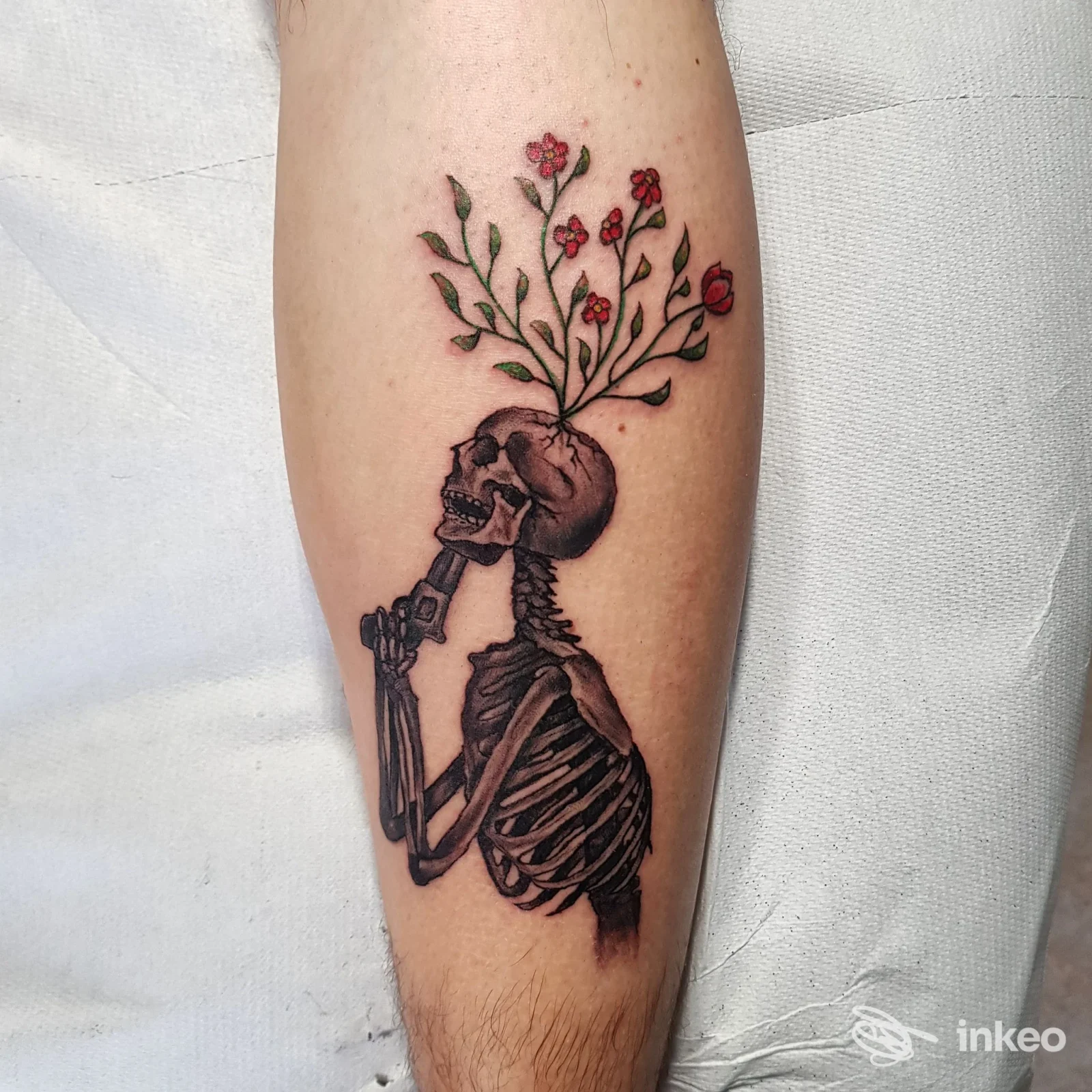 Tatuaggio su avambraccio raffigurante uno scheletro con fiori che sbocciano dalla testa. Black Cat Tattoo by Cinzia Santoro, San Vito dei Normanni.