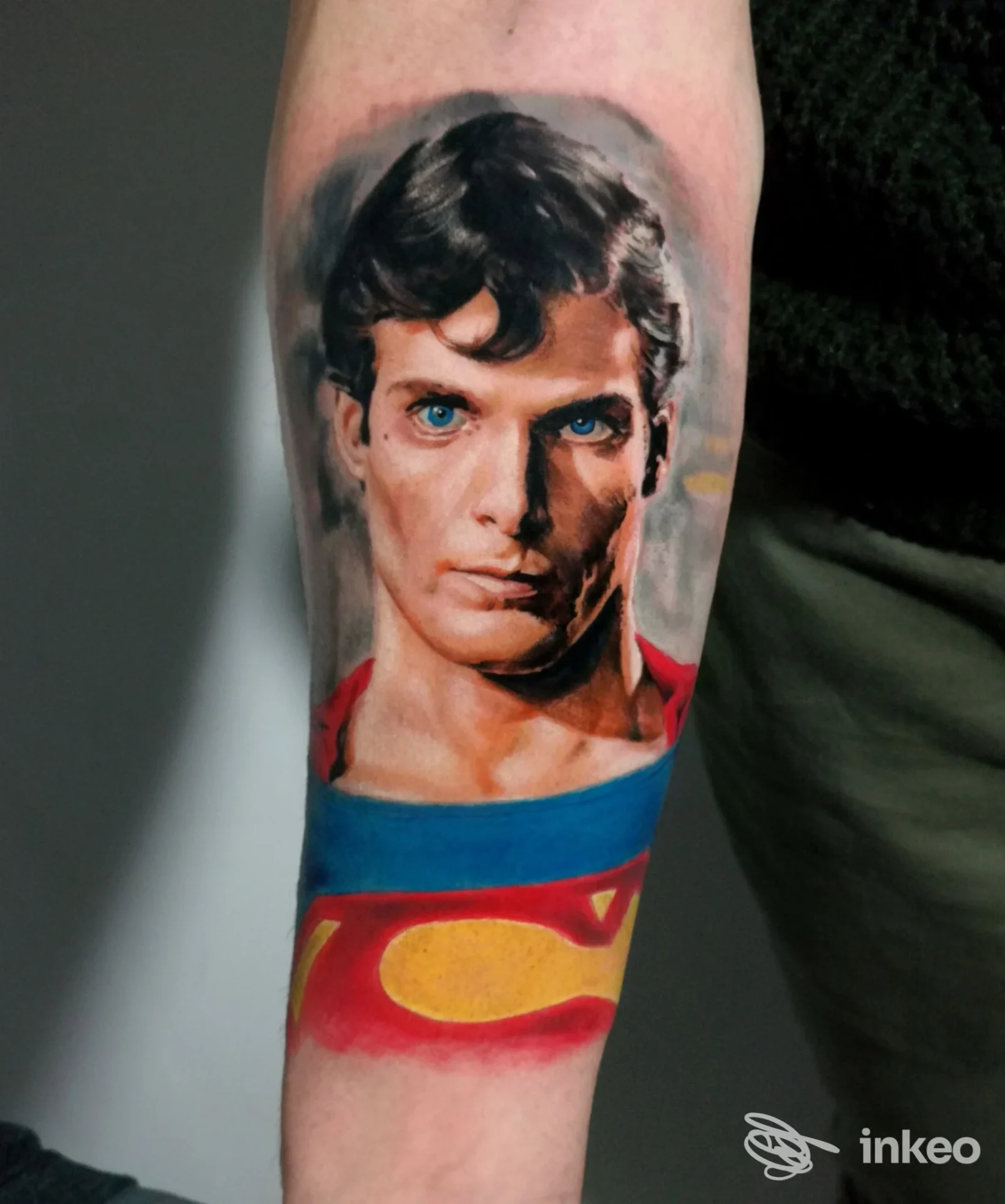 Tatuaggio realistico a colori sul davanti dell'avambraccio: ritratto di Superman con parte del logo 'S', Daniele Stella Tattoo Shop, Bari.