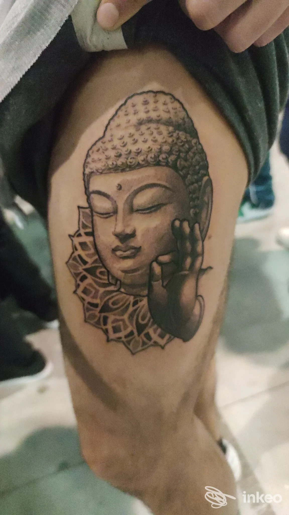 Tatuaggio realistico in nero e grigio della testa di Buddha sulla coscia, immagine inviata da Dermal Art Tattoo Studio Di Buono Rocco, Gravina in Puglia.