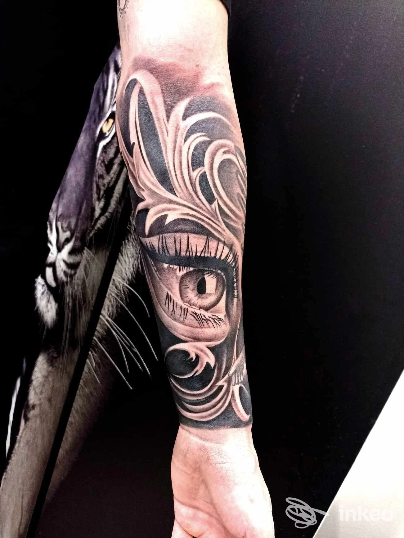 Tatuaggio realistico in bianco e nero con un occhio ornamentale sull'avambraccio, lavoro di Eureka Ink Tattoo a Capurso.