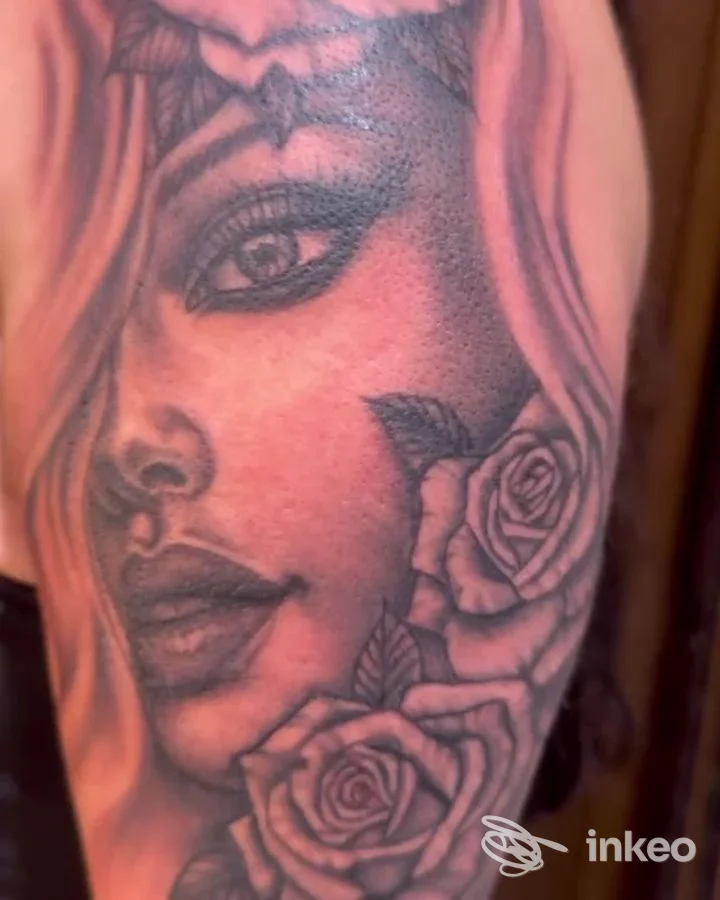 Dettaglio di un tatuaggio realistico in bianco e nero di volto femminile e rose, realizzato da Ink Lady Tattoo a Gallipoli.
