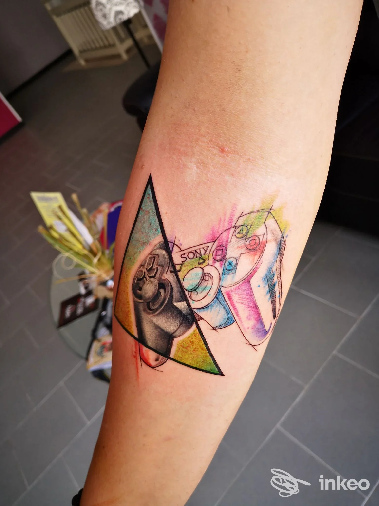 Tatuaggio colorato su avambraccio con controller PlayStation stilizzati, Lotus Noir Tattoo Studio di Pisconti Luana, Manduria.