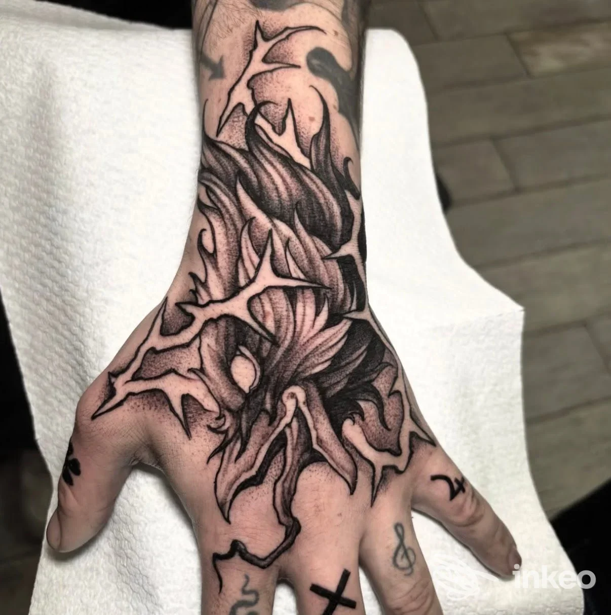 Tatuaggio blackwork sul dorso della mano e polso, con dettagli a linee spezzate e ombreggiature, foto fornita da In Cold Blood Tattoo Studio, Taranto.