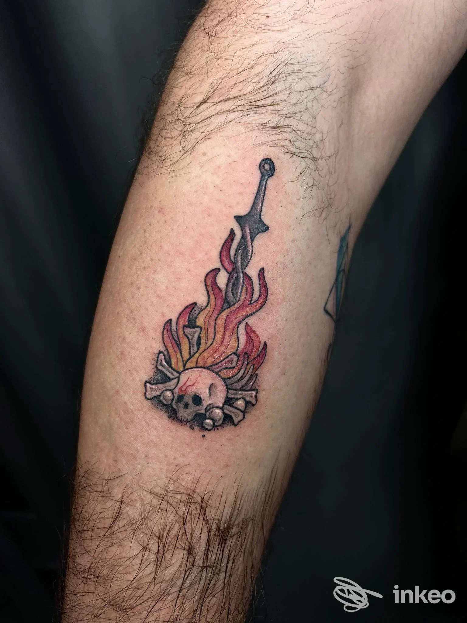 Tatuaggio a daga con fiamme e teschi sull'avambraccio, foto inviata da MAAD Tattoo Shop a Matino.