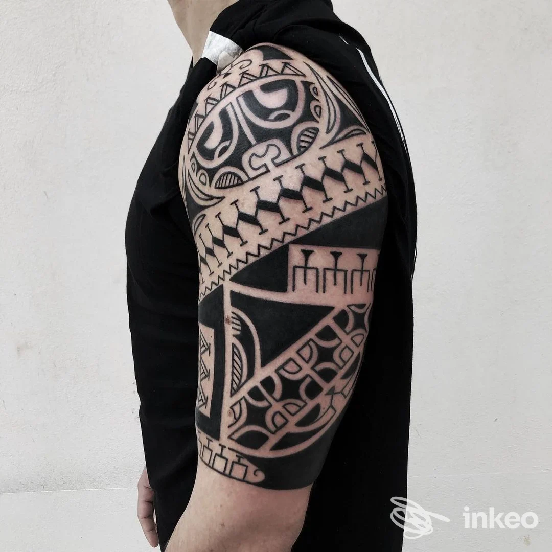 Mezza manica tribale nera su braccio e spalla, lavoro di Macko Tattoo Shops Bari, Bari.