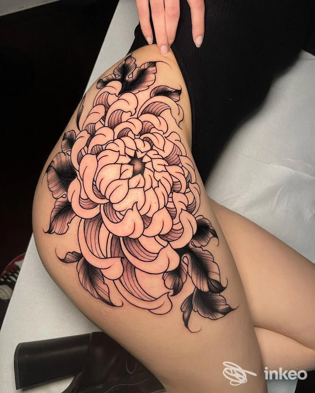 Tatuaggio floreale grande sulla coscia, fotografia dello studio Macko Tattoo Shops a Monopoli.