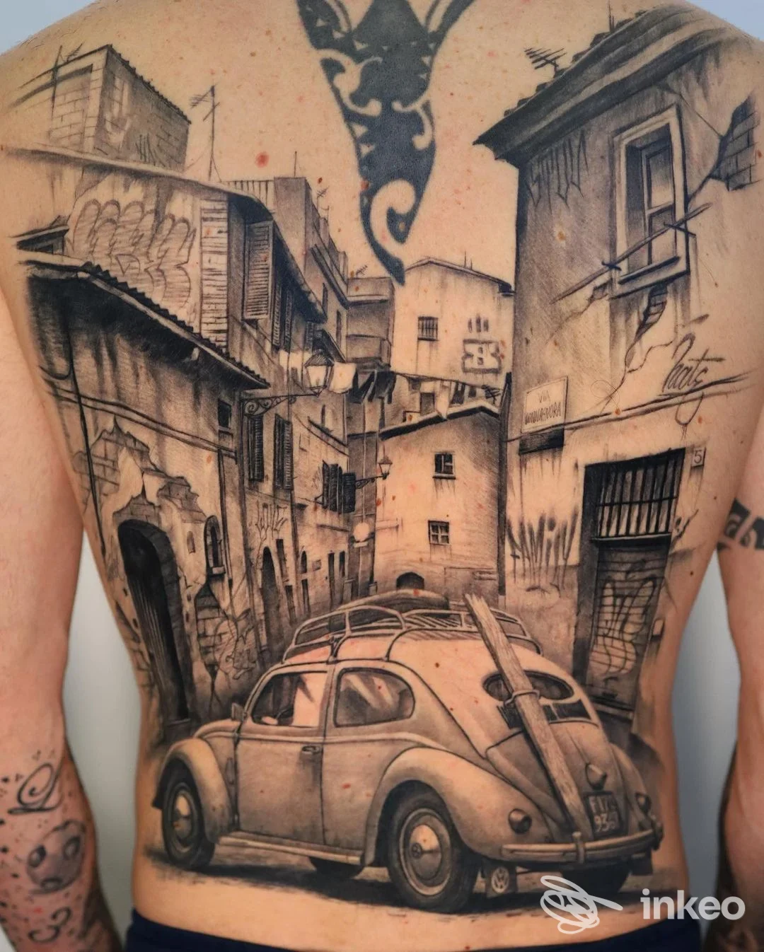 Tatuaggio realistico in bianco e nero che copre l'intera schiena con una scena urbana prospettica e un'auto d'epoca — Macko Tattoo Shops Monopoli, Monopoli.