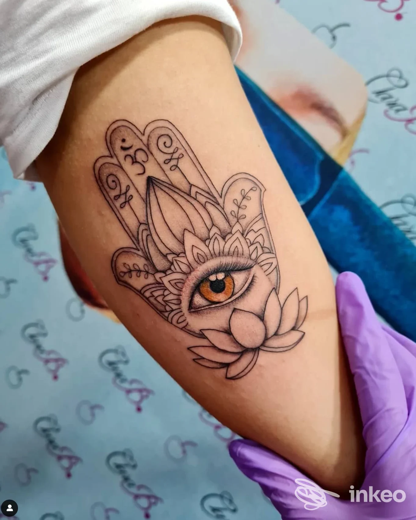 Tatuaggio mano di Fatima con occhio ambra e fiore di loto sull'avambraccio, realizzato da Nadia Art Tattoo a Martina Franca.