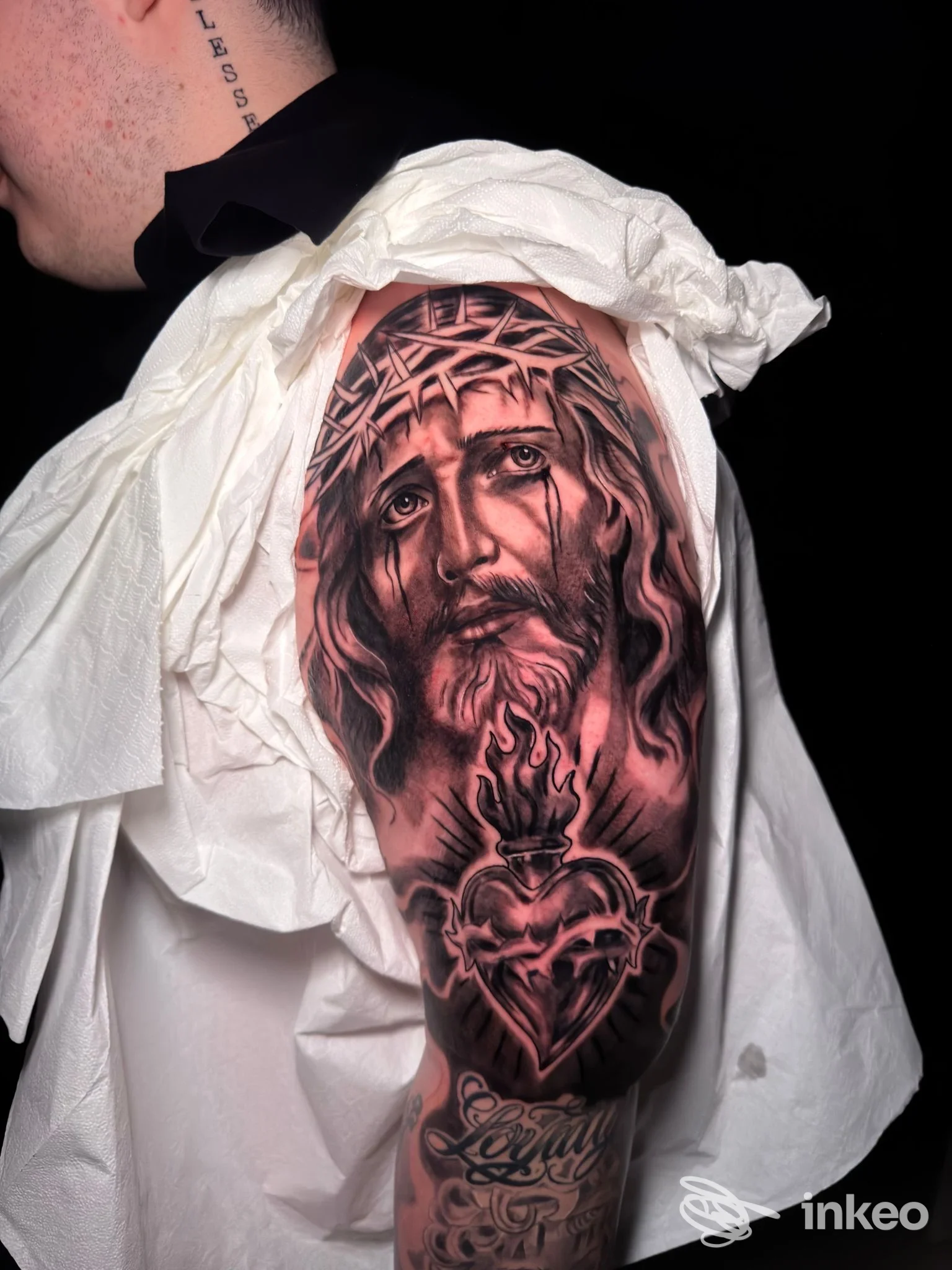 Tatuaggio realistico su spalla e braccio superiore con volto di Cristo e Sacro Cuore, ROMANS TATTOO, Bari.