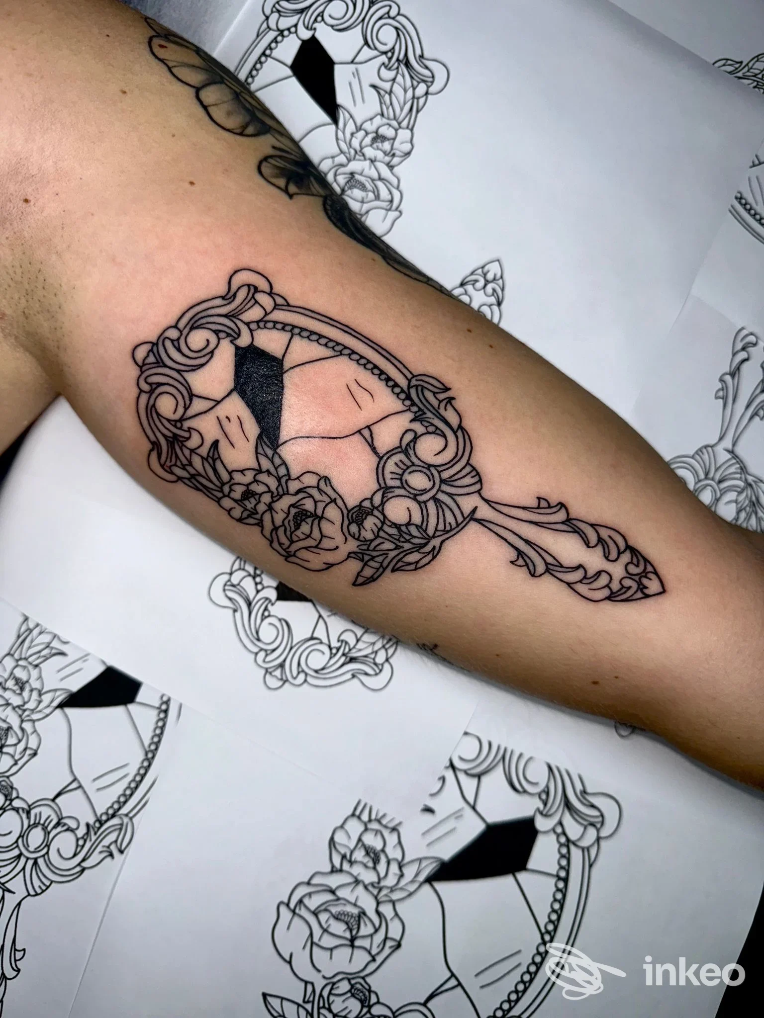 Tatuaggio su avambraccio raffigurante uno specchietto ornamentale con volto e rose - ROMANS TATTOO, Bari.