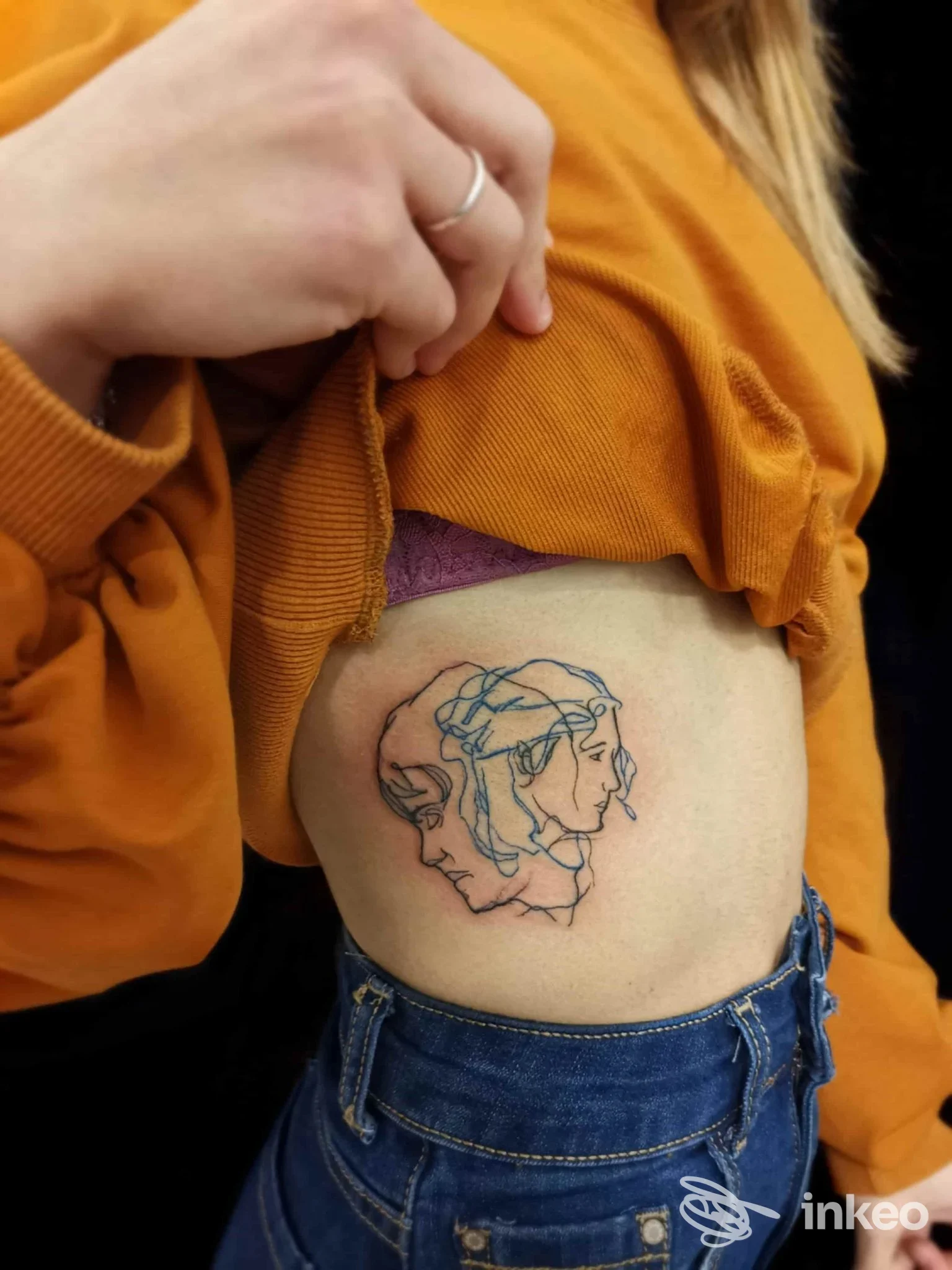 Tatuaggio a linee doppie di due profili sul fianco, foto inviata dallo studio Scream Tattoo Ink ad Altamura.