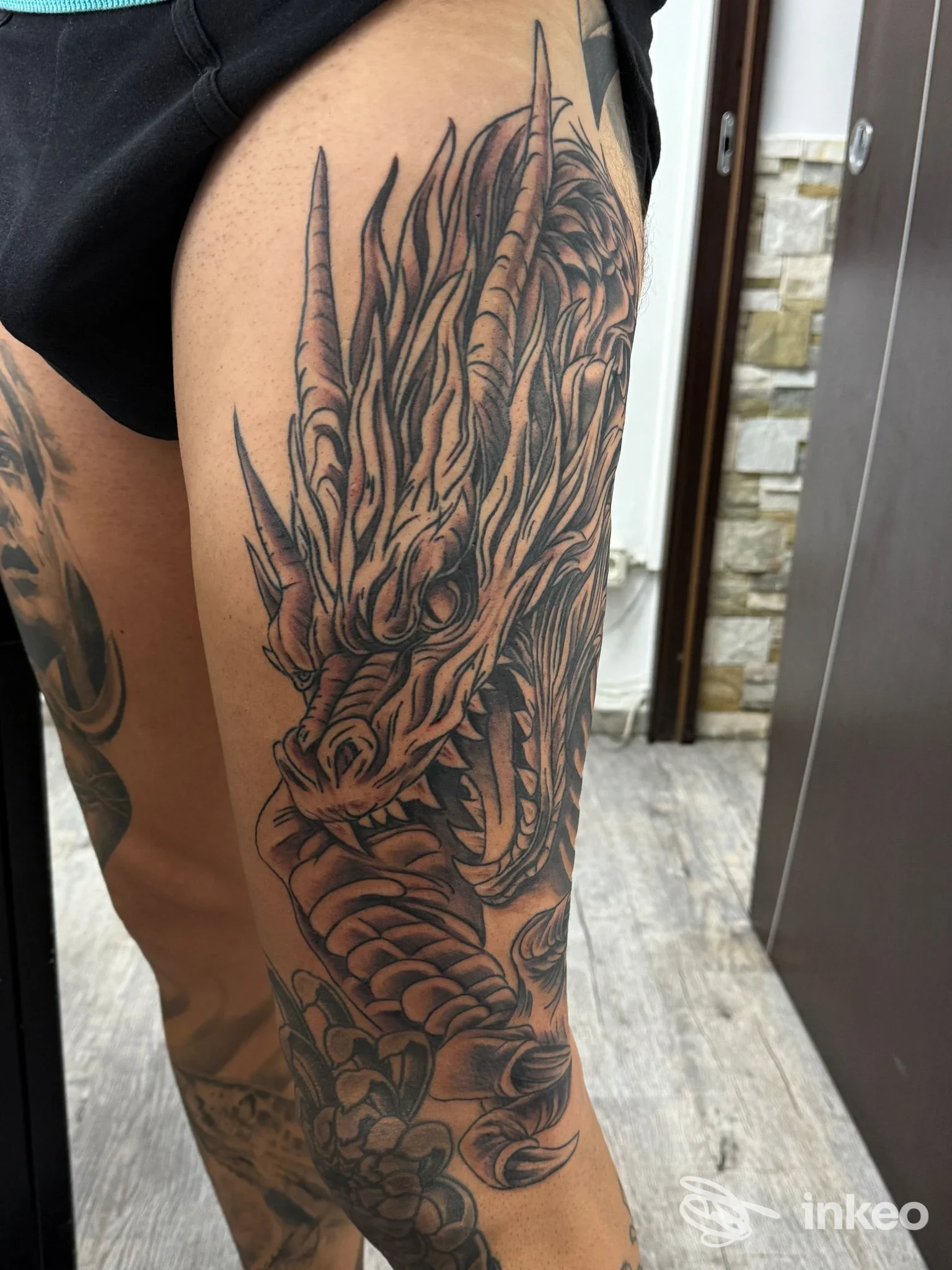 Ampio tatuaggio a tema drago in nero e grigio sulla coscia, fotografato nello studio Simone Art Tattoo a Bari.