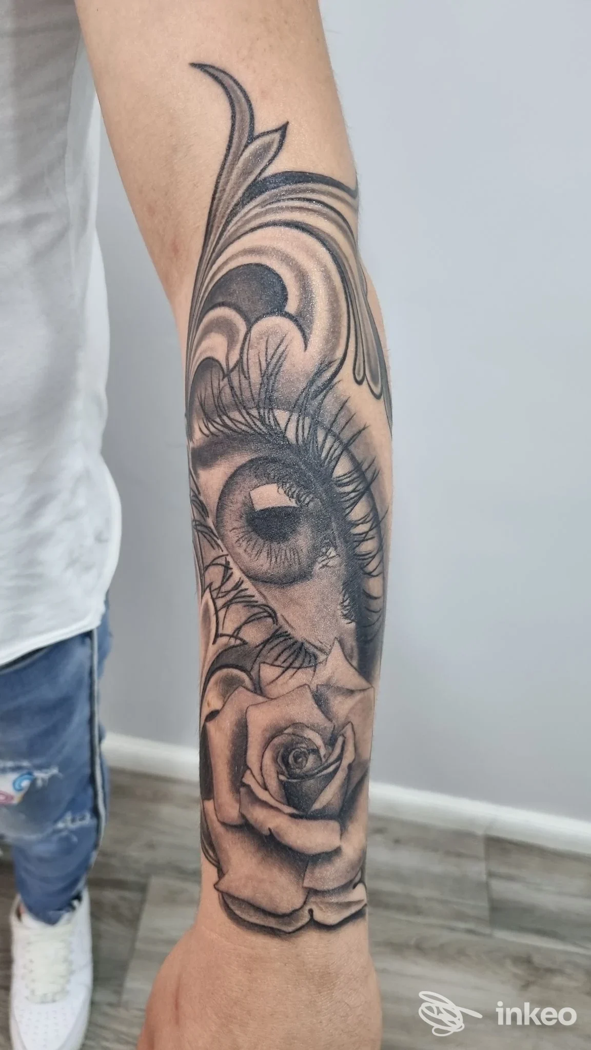 Tatuaggio realistico in bianco e nero con occhio e rosa sull'avambraccio, Tattoo Raven, Taranto.