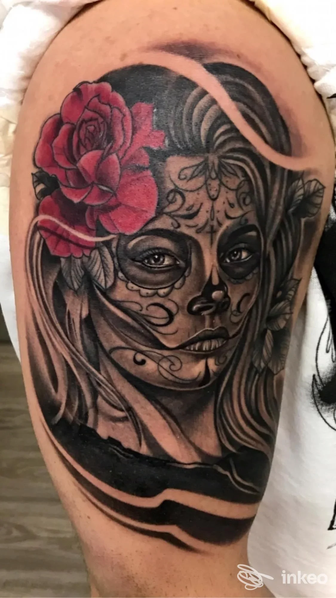 Tatuaggio su bicipite con volto femminile in stile sugar skull e rosa rossa, realizzato da Tattoo Wave di Di Luzio Marco e Co Sas, Taranto.