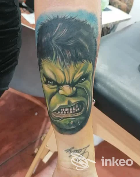 Primo piano di un tatuaggio realistico a colori del volto di Hulk sull'avambraccio, Tatuaggi Bloodline Tattoo, Manduria.
