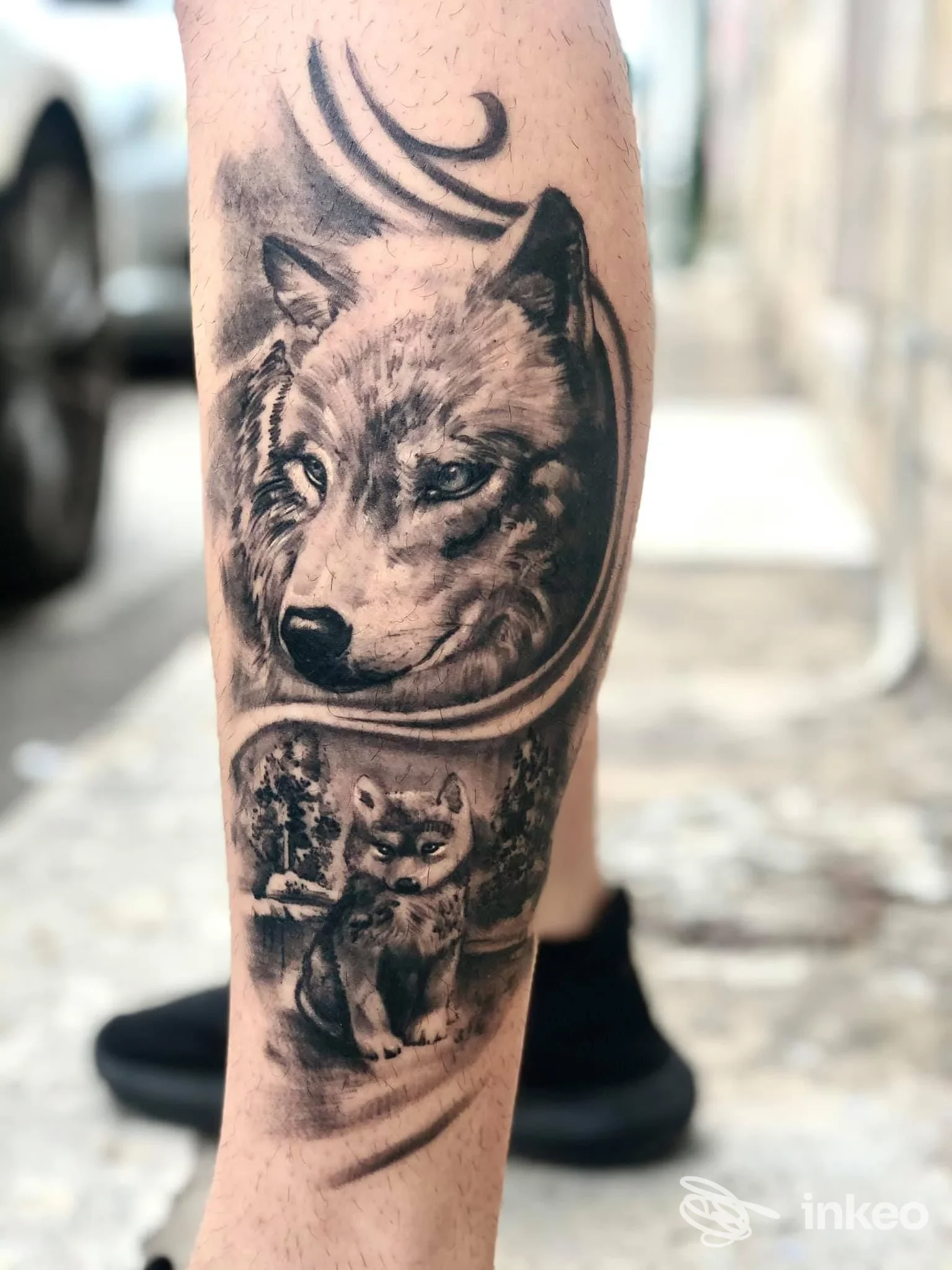 Polpaccio tatuato con ritratto realistico di lupo e scena con cucciolo, foto per Bloodline Tattoo, Manduria.