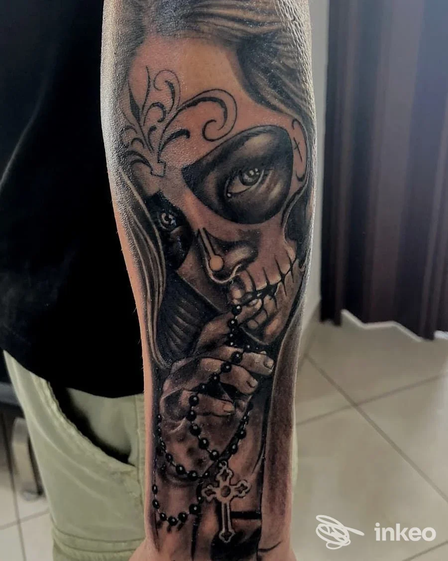 Tatuaggio realistico black & grey su avambraccio raffigurante volto scheletrico con rosario, Tesori d'Oriente Studio Tattoo & Piercing, Ceglie Messapica.