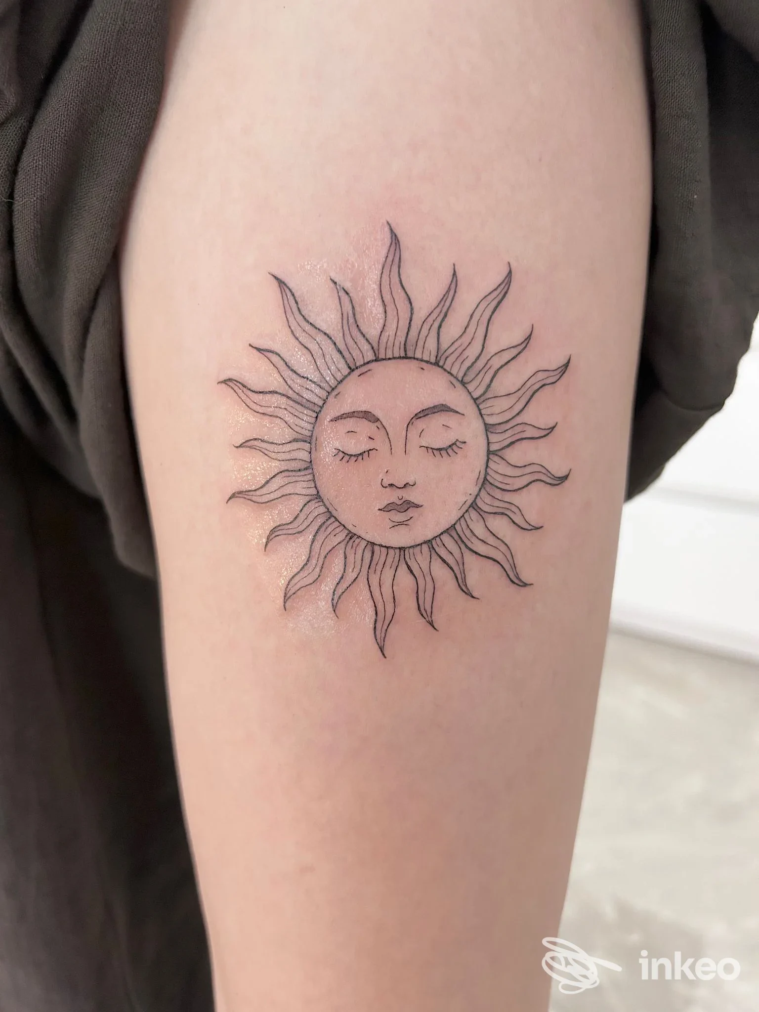 Tatuaggio a linee nere di un sole stilizzato sull'avambraccio, foto fornita da REBEL ANGEL STUDIO TATTOO, Ceglie Messapica.