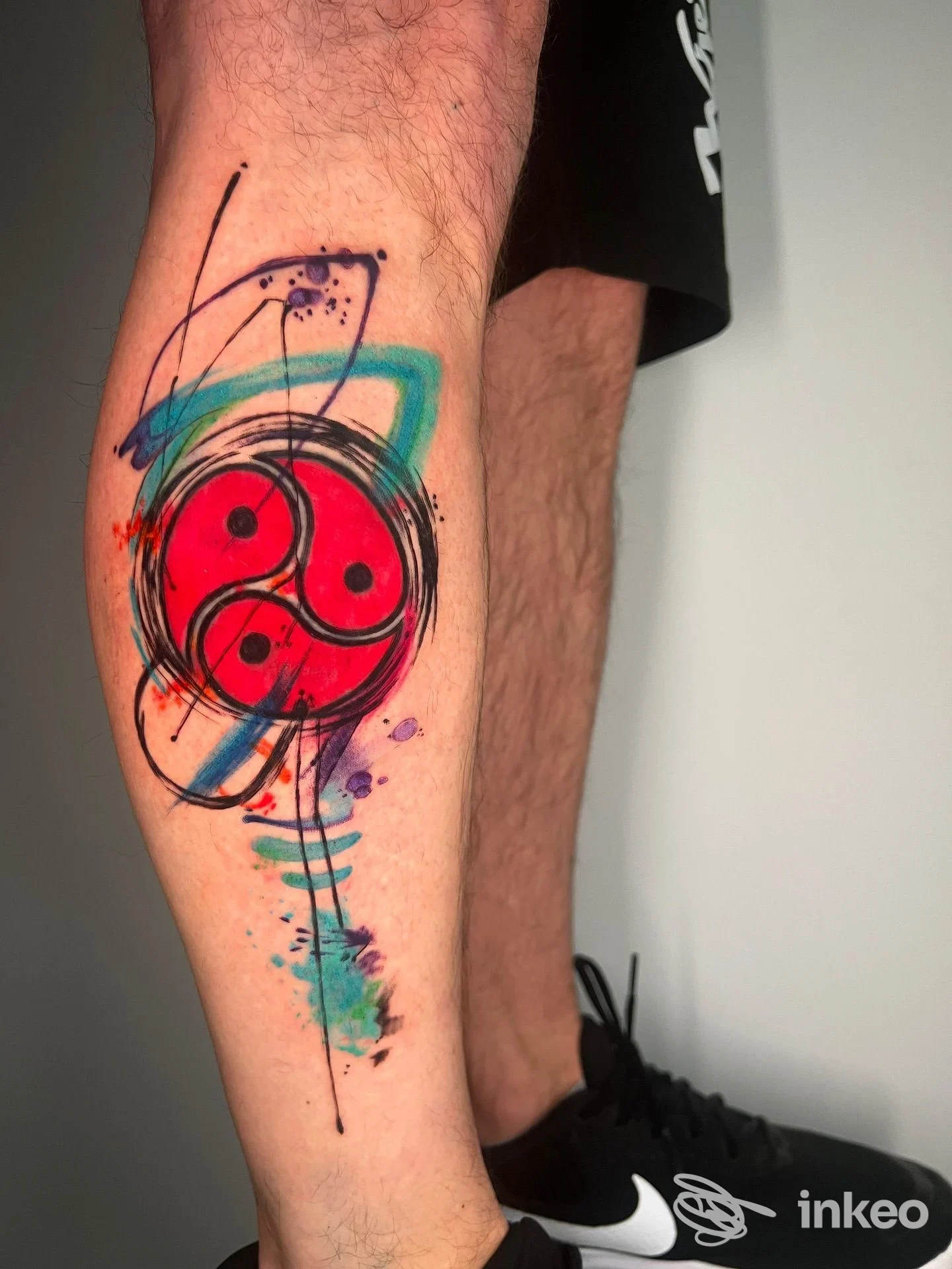 Tatuaggio colorato su polpaccio con motivo circolare e pennellate, Tatuaggeria Castellana Grotte.