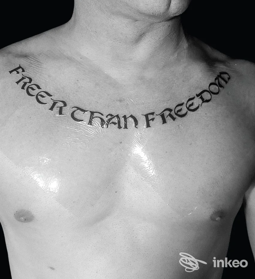 Tatuaggio testuale arcuato sul petto, foto di UrbanINK Tattoo Studio a San Cesario di Lecce, dettaglio su collo e clavicole.