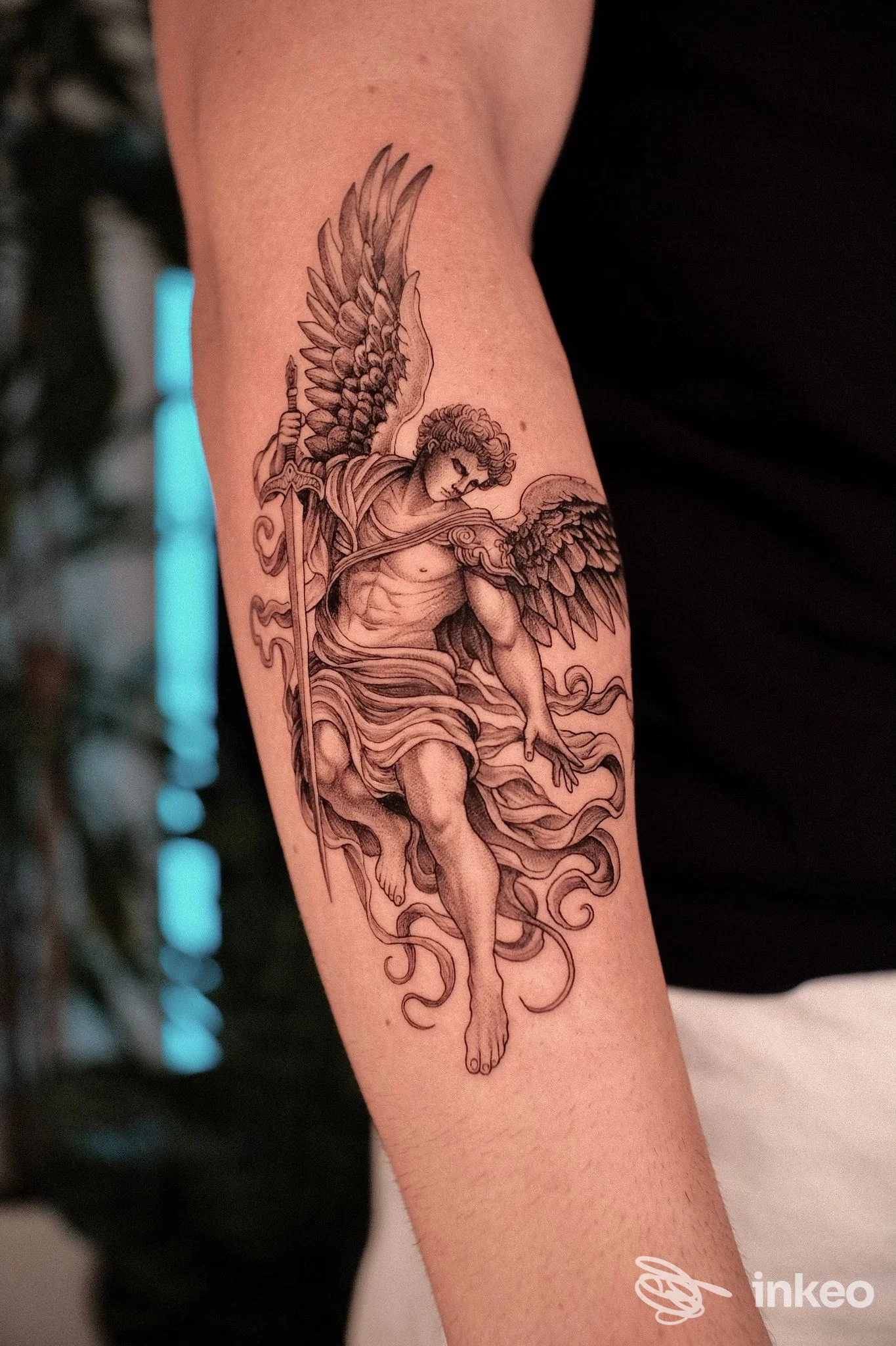 Tatuaggio realistico in nero di un arcangelo sull'avambraccio, foto per Vision of Light | Tattoo a Castellana Grotte.