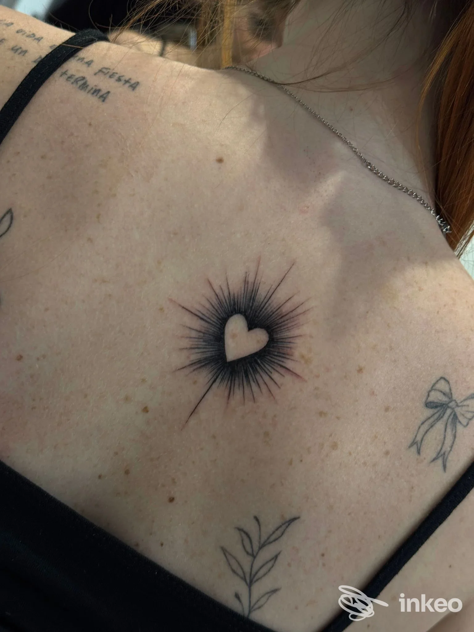 Cuore stilizzato tatuato sulla parte alta della schiena con raggi neri, foto di studioz — Triggiano.