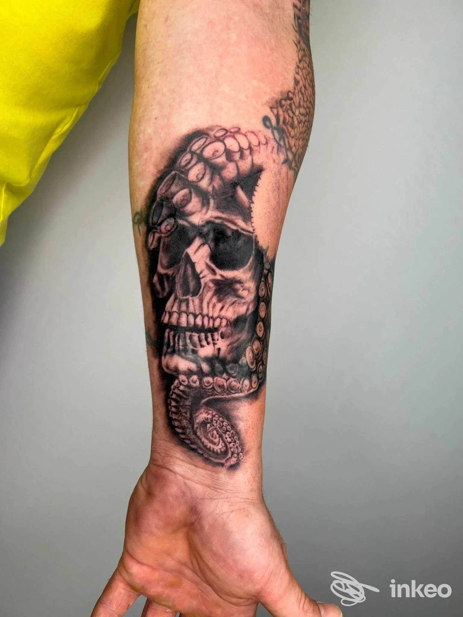 Tatuaggio realistico di teschio con serpente sull'avambraccio realizzato su pelle umana, visibile nello studio Stay True Tattoo Passion.