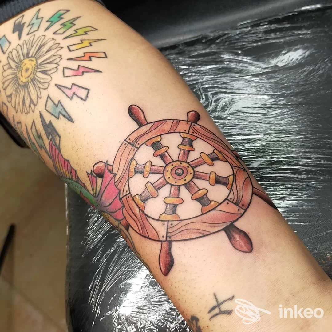 Tatuaggi colorati su avambraccio con timone nautico, foto fornita da TATTOO GIS-ART STUDIO, Isili.
