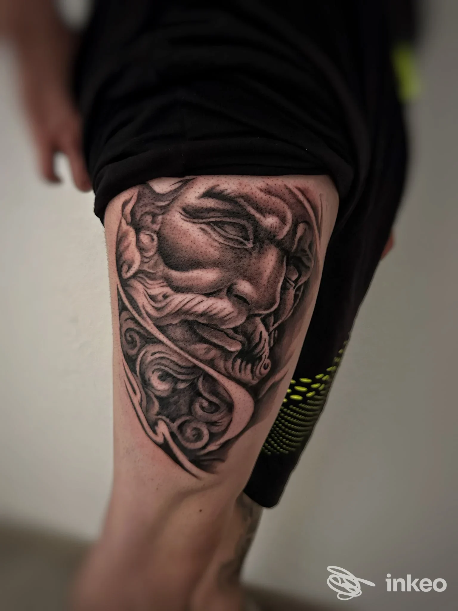Tatuaggio realistico in bianco e nero su coscia che ritrae un volto classico; Tattoo Studio Mauro Pani, Villaspeciosa.