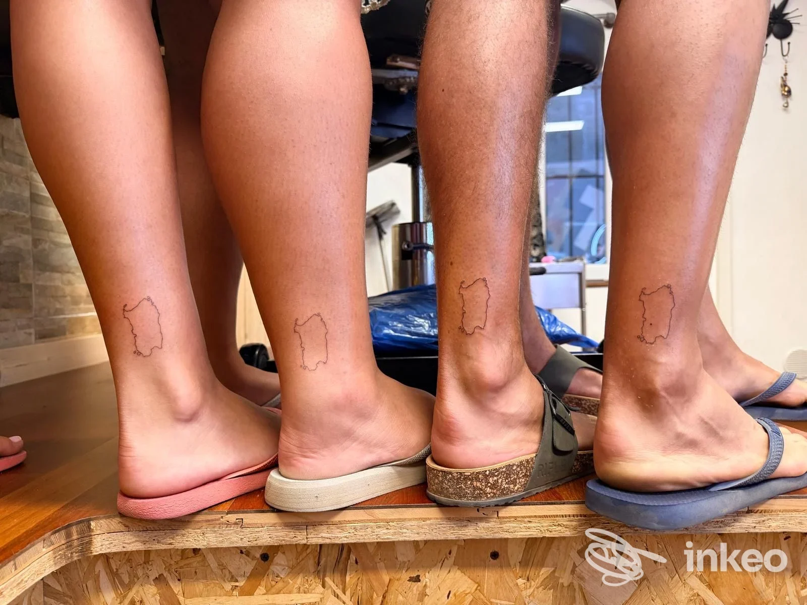 Quattro caviglie con lo stesso piccolo tatuaggio a contorno, foto scattata nello studio T'ink tattoo studio ad Alghero.