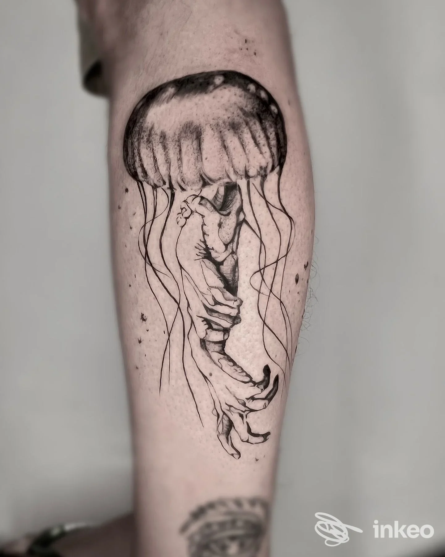 Tatuaggio su avambraccio raffigurante una medusa che sfuma in una mano scheletrica, lavoro in bianco e nero — Tattooami Valentina Fadda, Cagliari.