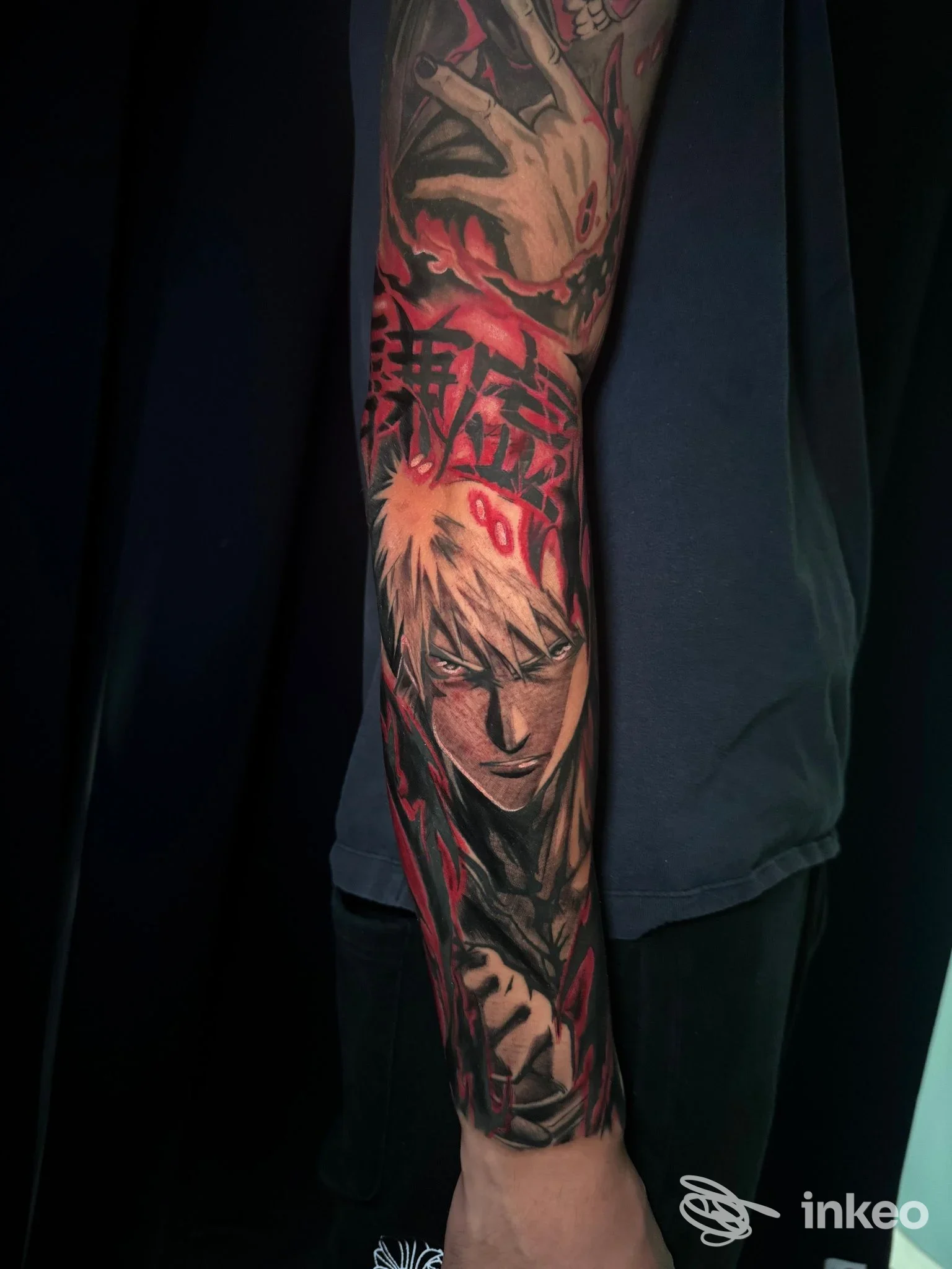 Manica tatuata sull'avambraccio con un personaggio in stile illustrativo e accenti rossi, foto Three Little Monkeys Tattoo Studio, Sassari.