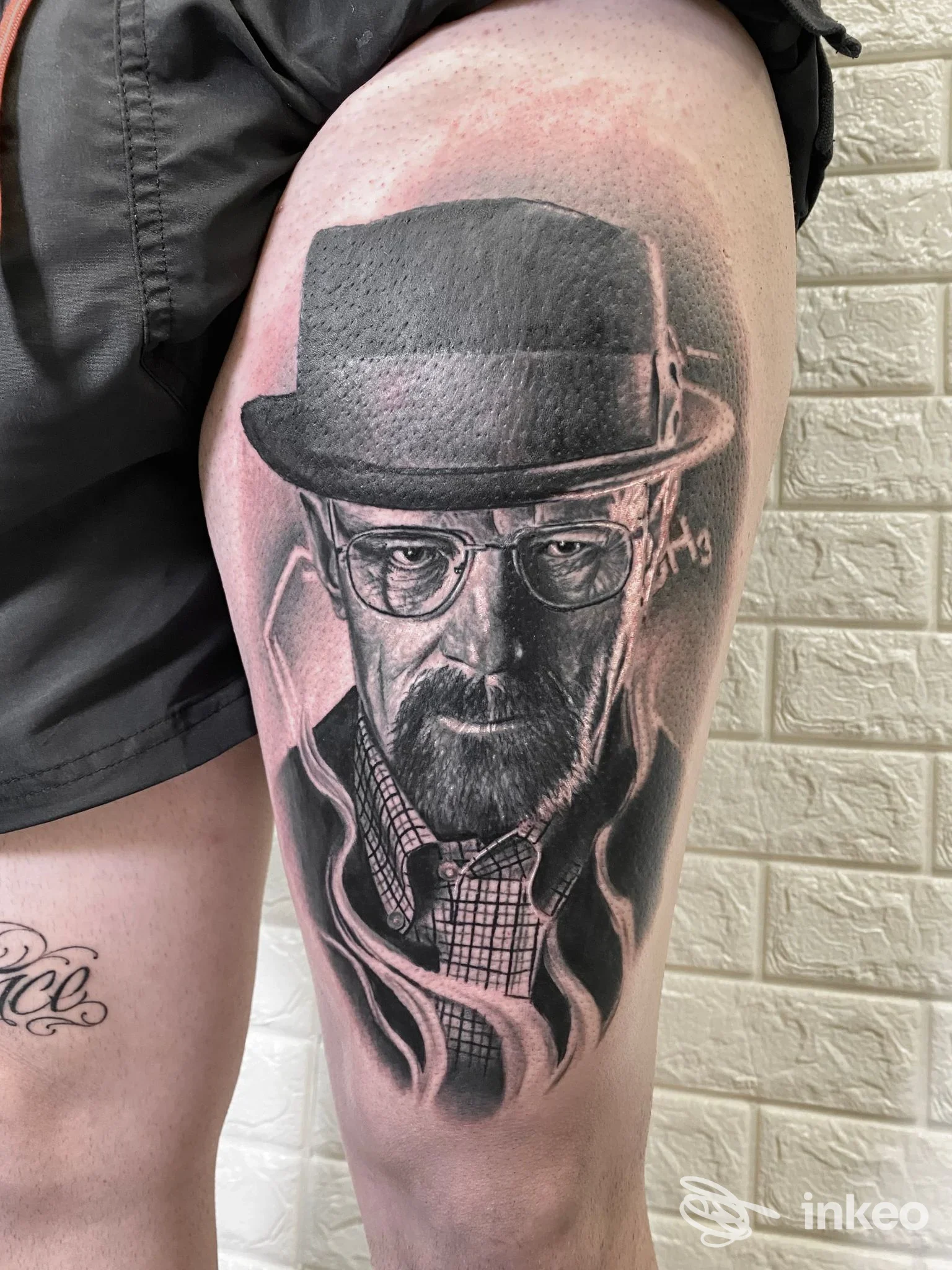Tatuaggio ritratto black & grey sulla coscia, volto con cappello e occhiali; lavoro di True Love Tattoo Studio di Matteo Masala, Sestu.