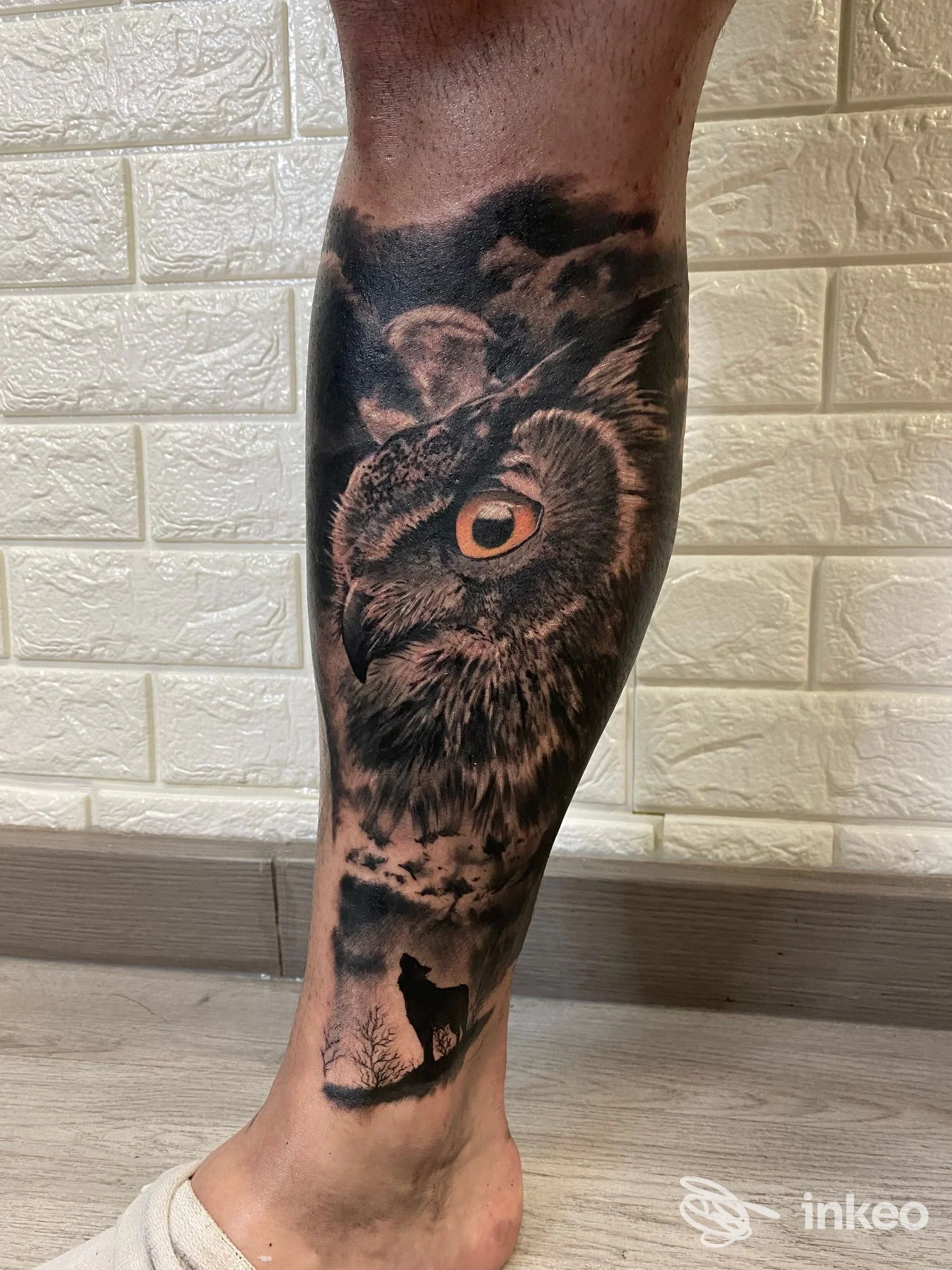 Tatuaggio realistico di un gufo sul polpaccio, con un piccolo lupo alla caviglia — True Love Tattoo Studio, Sestu.
