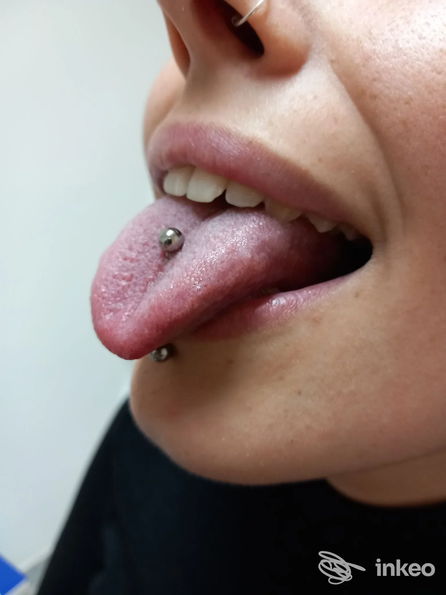 Primo piano di un piercing alla lingua e labbro inferiore, foto per Truccatore-Piercing, Olmedo.
