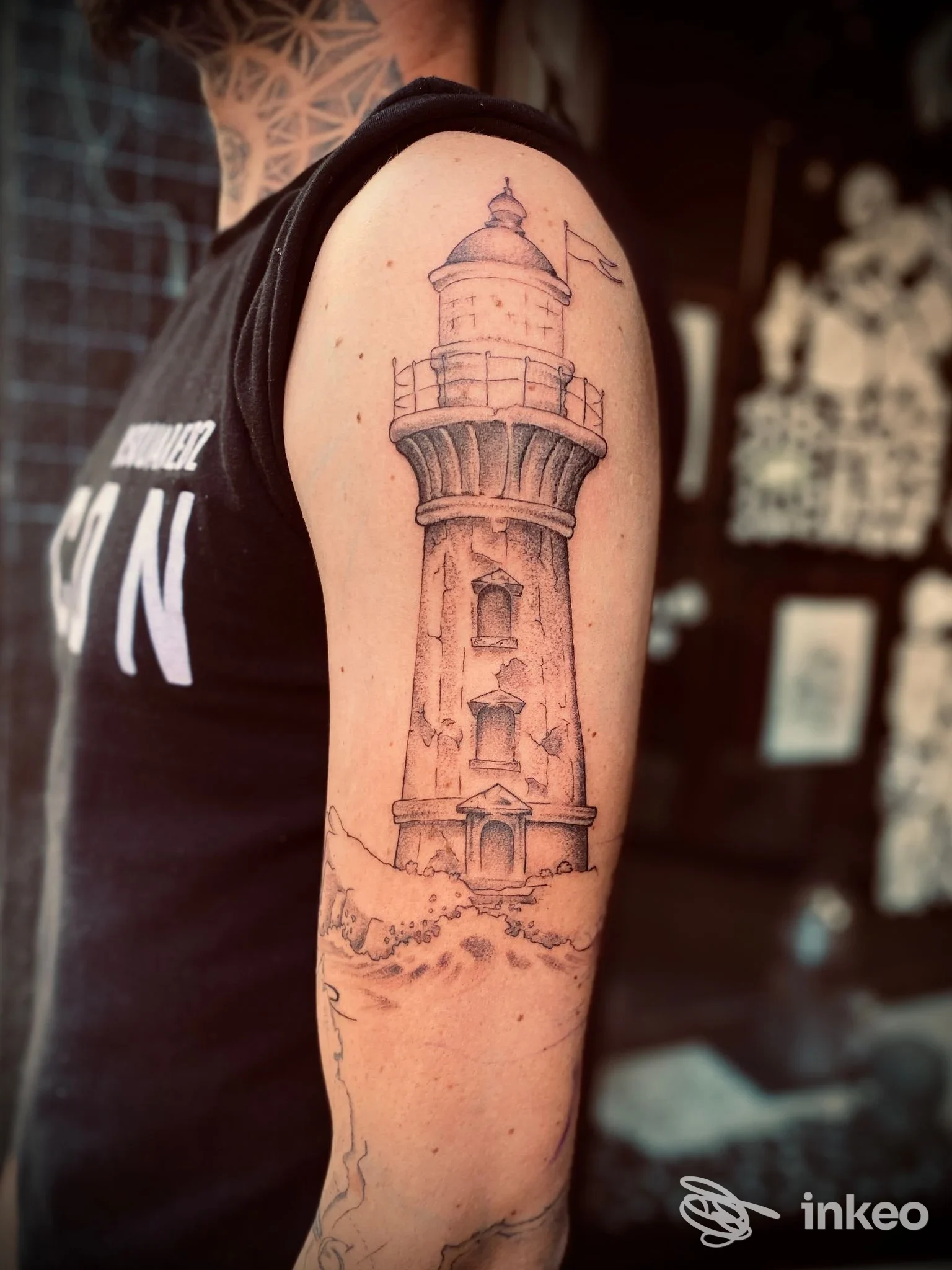 Tatuaggio faro su braccio sinistro realizzato da illegalink tattoo a Cagliari, dettaglio in stile linework e sfumature.