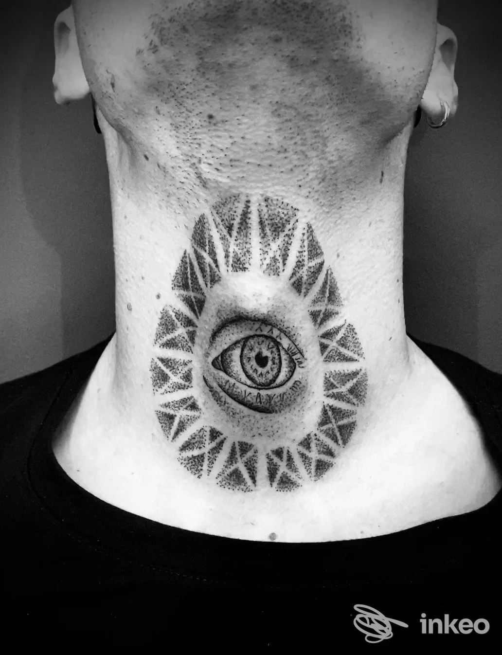 Tatuaggio a occhio stilizzato e motivi geometrici puntinati sul collo, foto fornita dallo studio illegalink tattoo di Cagliari.