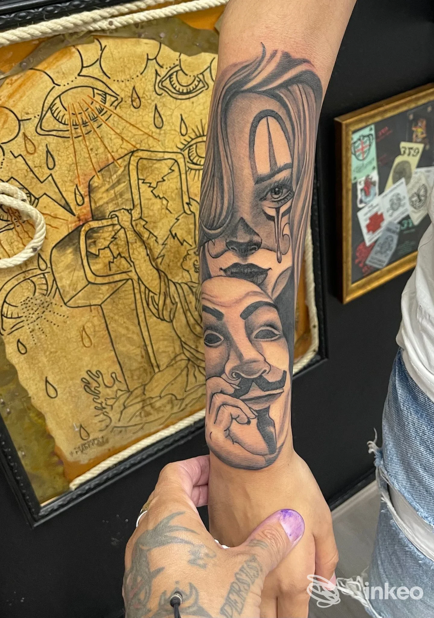 Tatuaggio realistico in bianco e nero di volti sovrapposti sull'avambraccio, foto fornita da 379 tattoo studio, Cagliari.