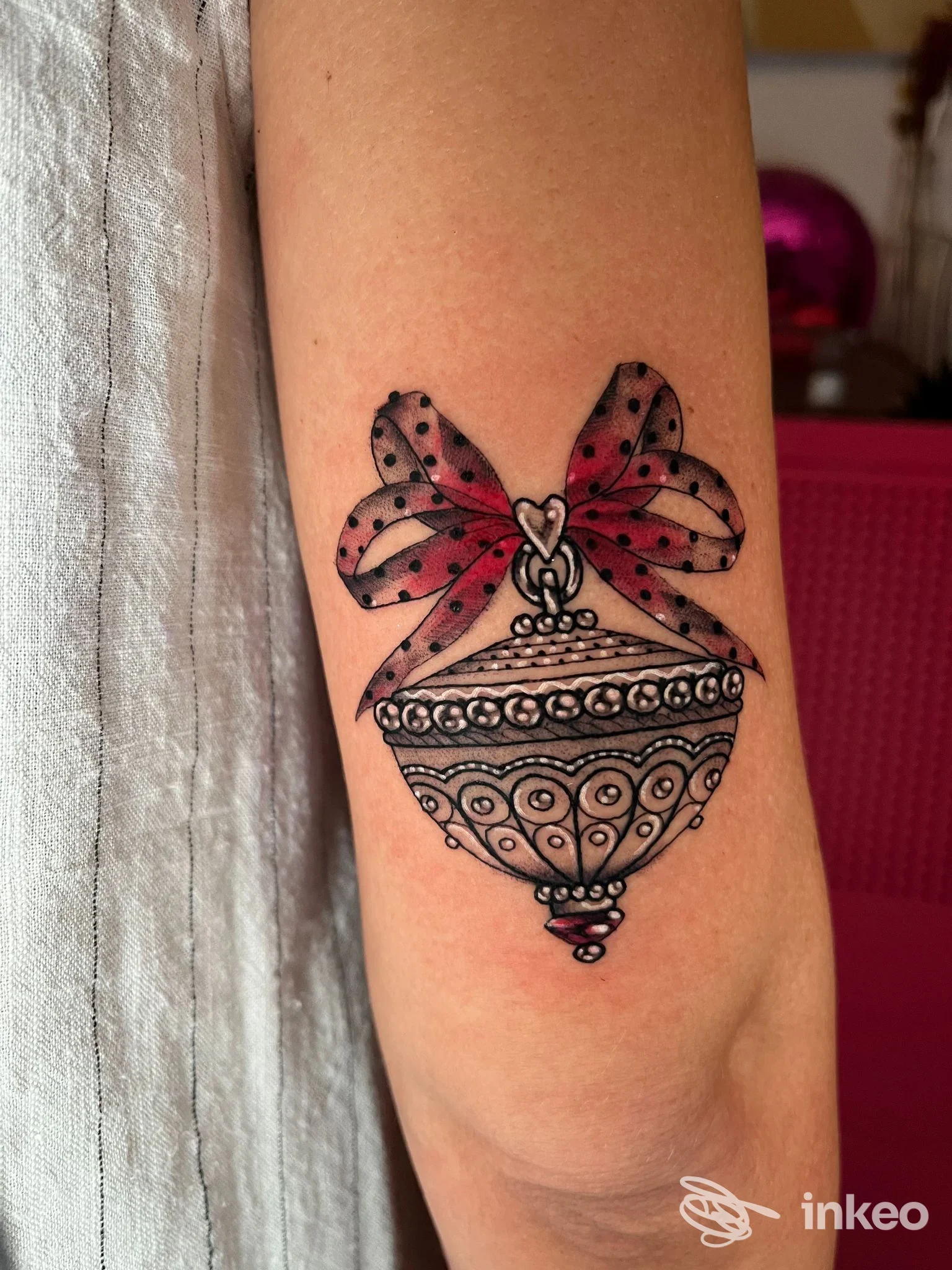 Tatuaggio ornamentale con pallina decorativa e fiocco sul avambraccio, fotografia di Baldùfura - CREATIVE TATTOO ATELIER, Alghero.