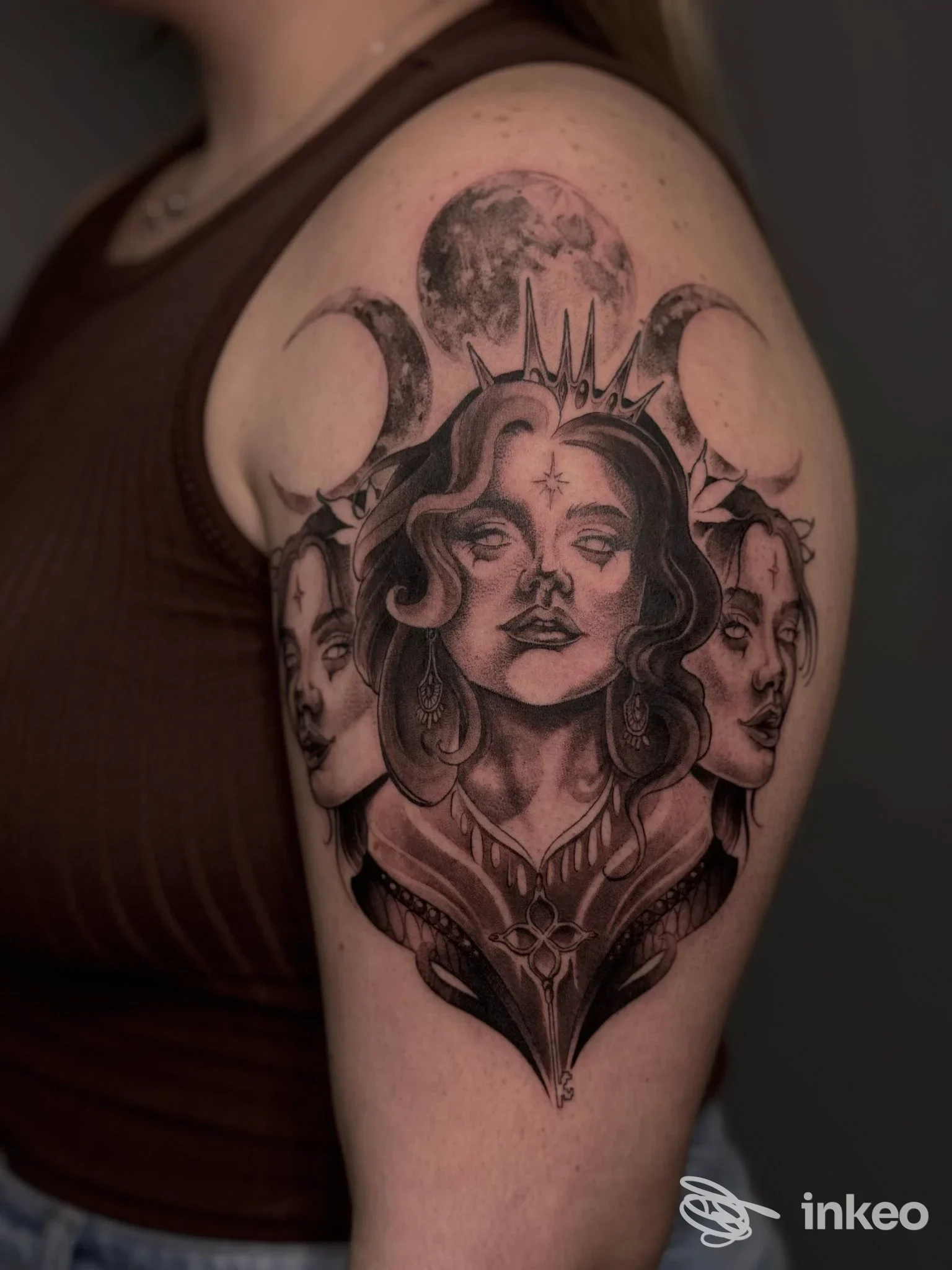 Tatuaggio black & grey con tre volti e lune sull'omero, Black and Grey Tattoo Shop, Monserrato.